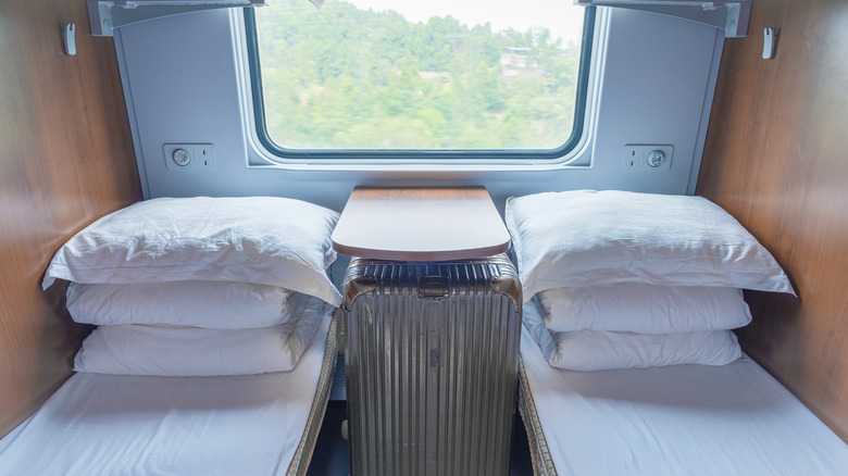 Interior of train sleeping car with two bunks and pillows