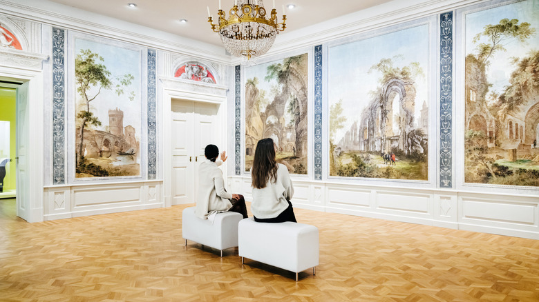 Two museum visitors sitting on bench