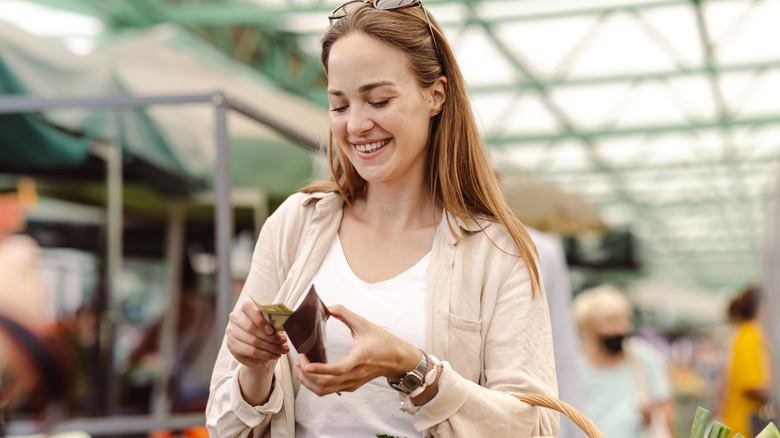 Woman pulling out money at a market
