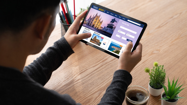 A person booking a flight on a tablet.