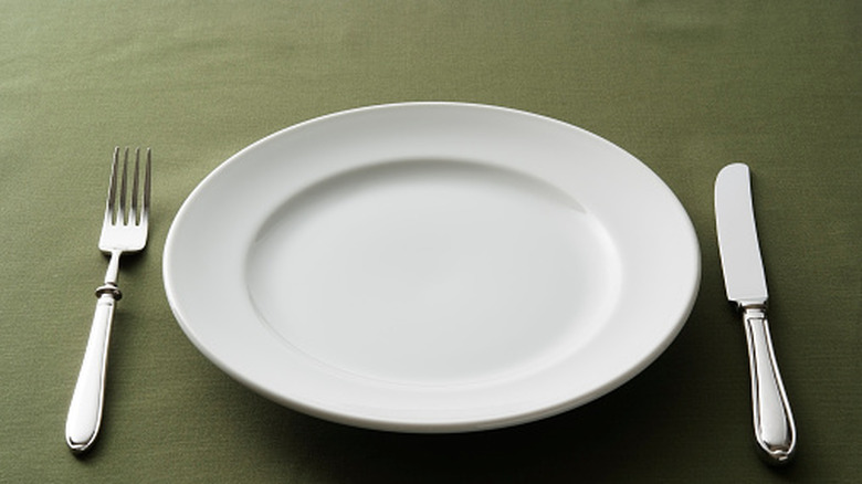 Plate surrounded by fork and knife