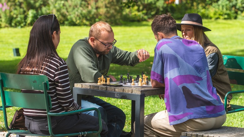 People gathered in a park playing chess
