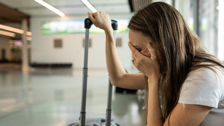 A stressed-out traveler with a suitcase.