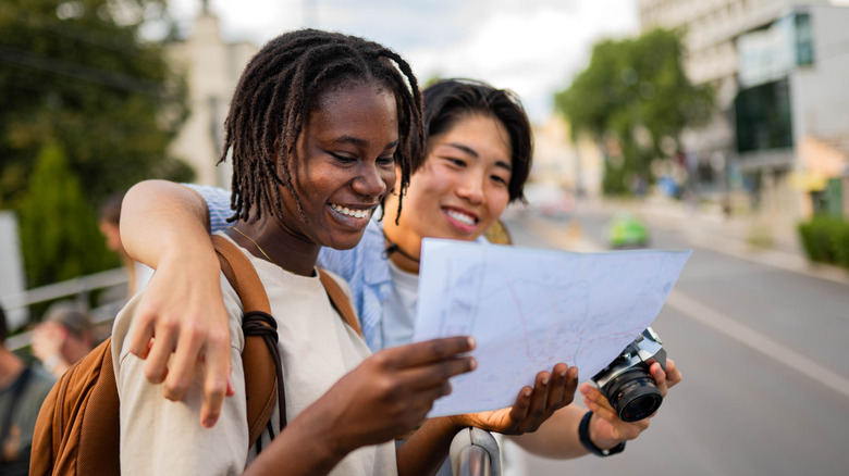 Happy travelers reading a map.