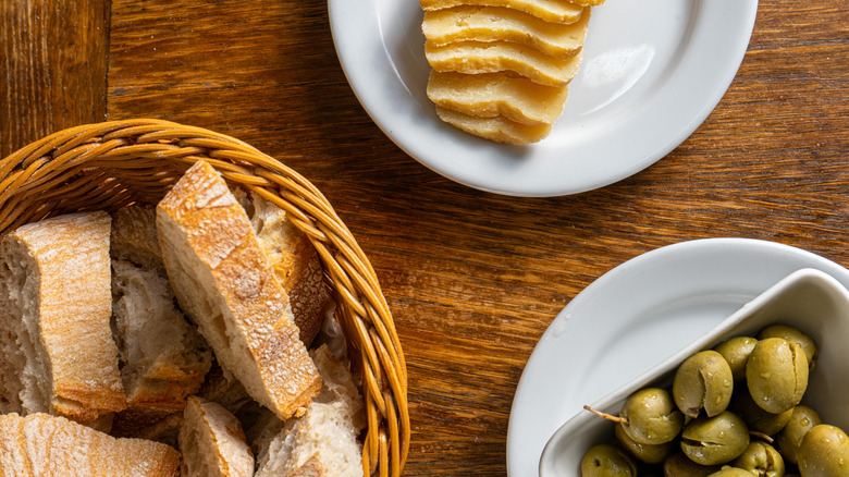 Plates of olives, bread, and cheese