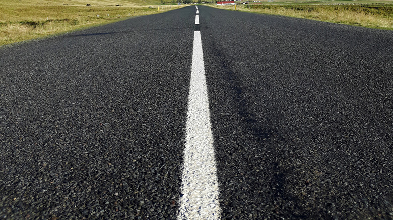 An open road with no cars in Iceland with mountains in the distance