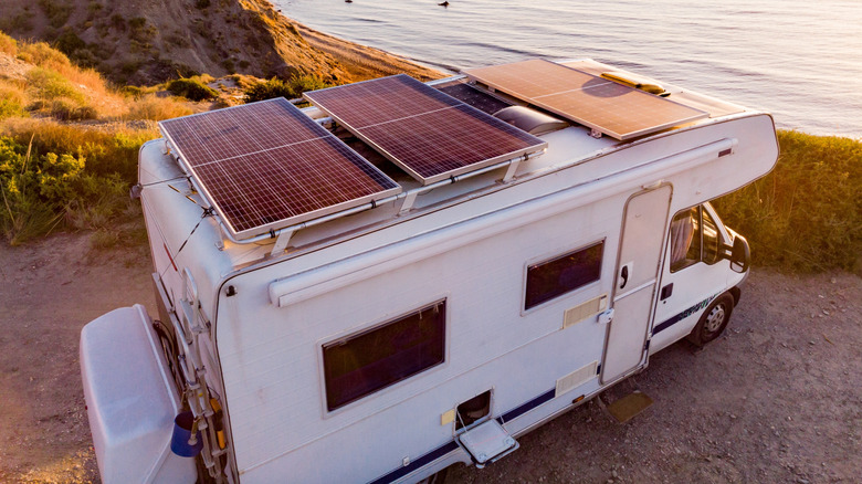 An RV with rigid solar panels mounted to the roof.
