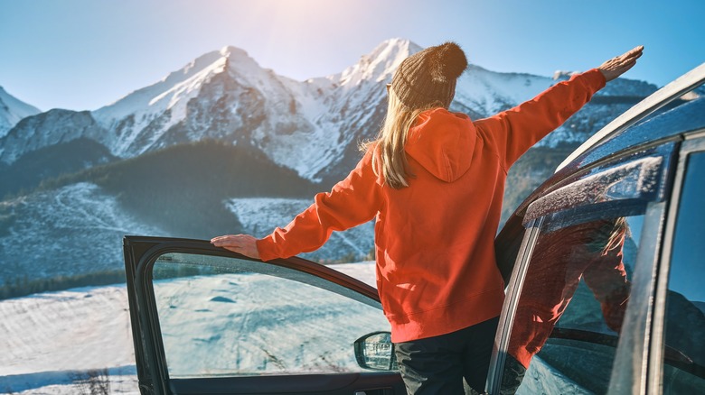 Woman viewing mountain by car