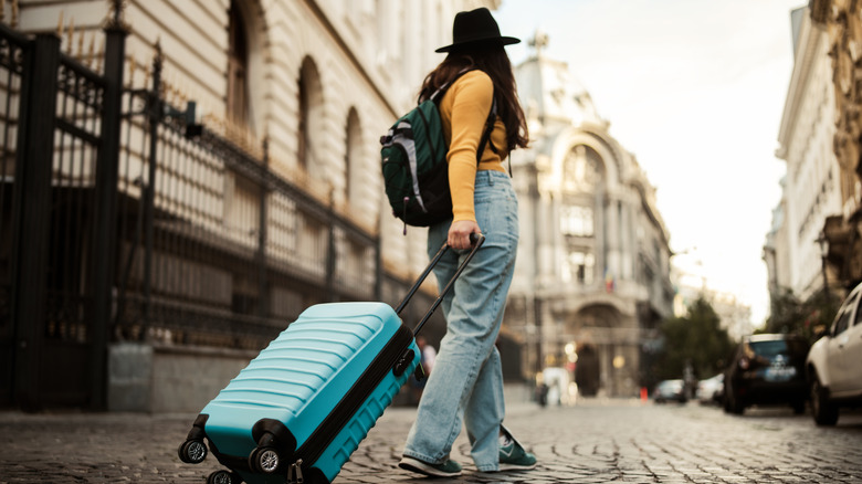 A woman pulling a suitcase through the streets of Bucharest.