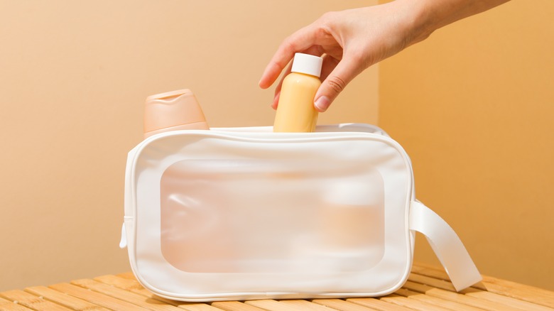 Putting a shampoo bottle in a toiletry bag