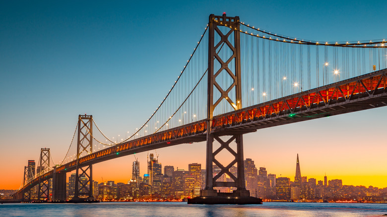 The Golden Gate Bridge in front of the San Francisco skyline at sunset