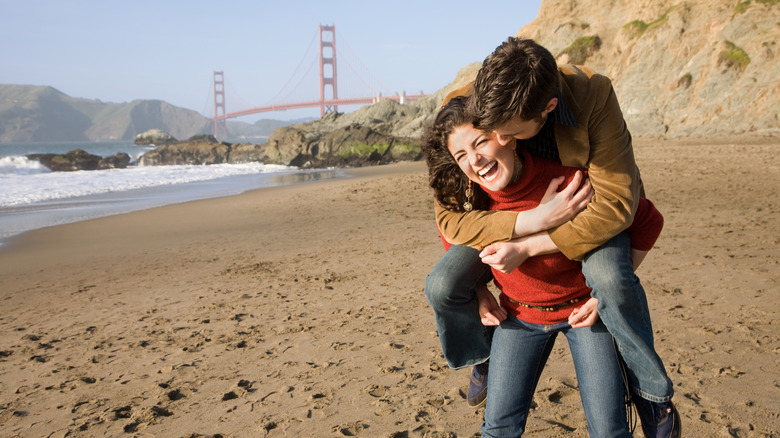 A couple on the beach with the Golden Gate Bridge in the background