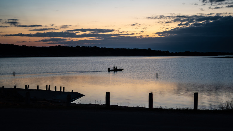Two people in a boat on a lake in Cedar Gap Park, at sunrise in Harker Heights, Texas