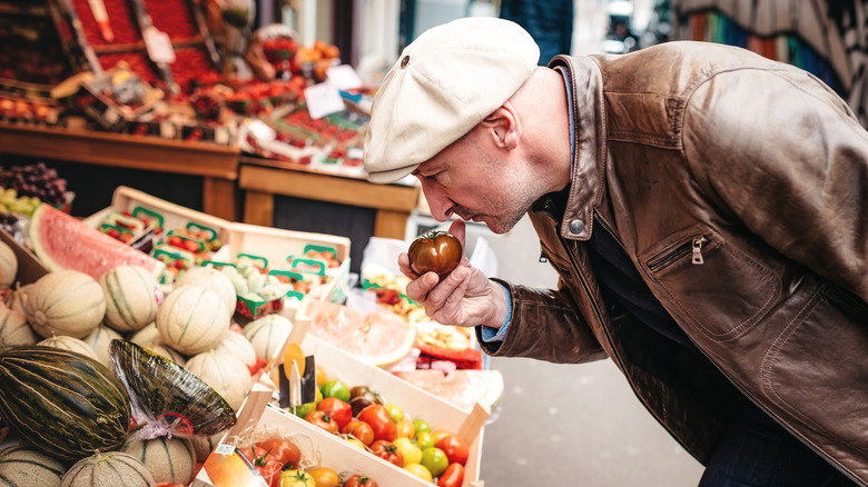 Shopper smelling produce in a French market