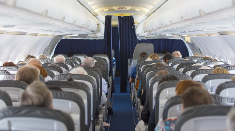 Passengers sitting in airplane cabin