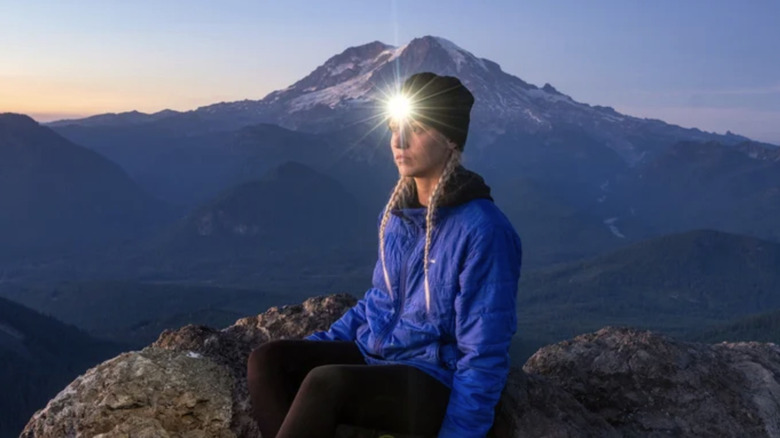 A woman wearing a beanie headlamp.