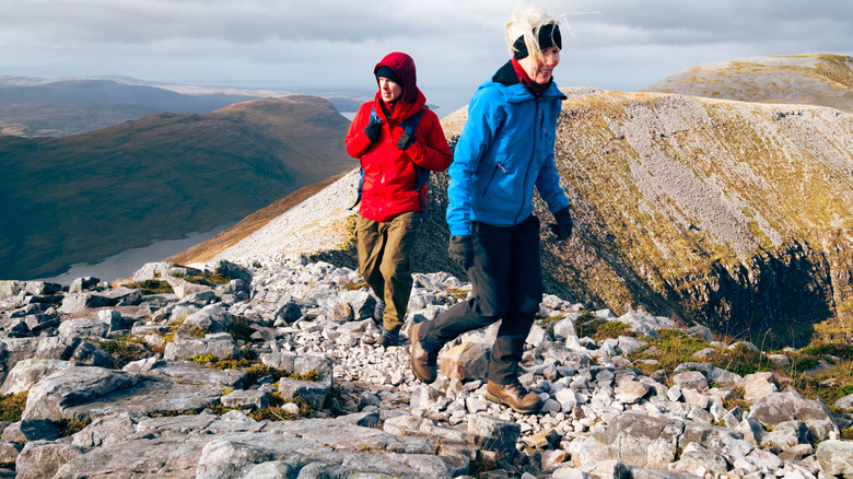 two hikers walking along a mountain ridge in cold weather gear