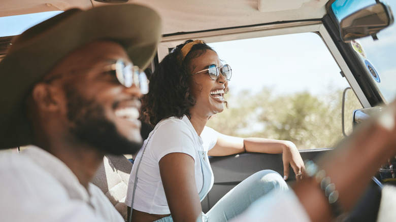 Young couple smiling while driving 