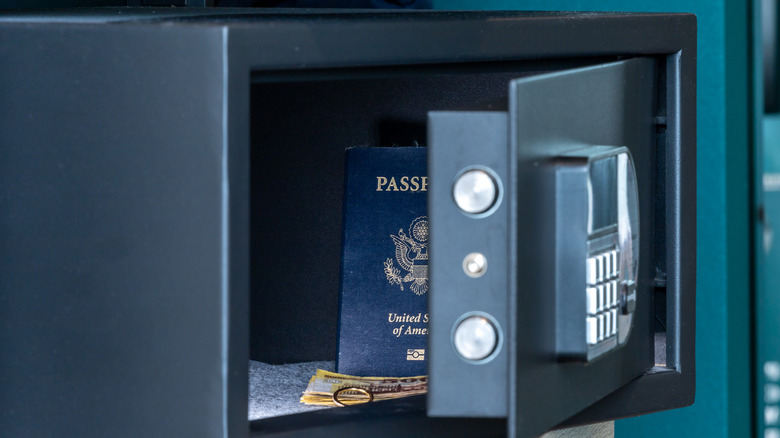 A hotel safe with a passport, money, and a ring