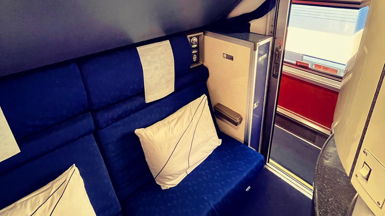 Two seats set up with pillows inside an Amtrak bedroom