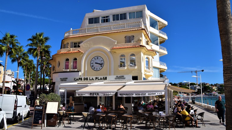 People at seaside promenade restaurant with clear blue sky