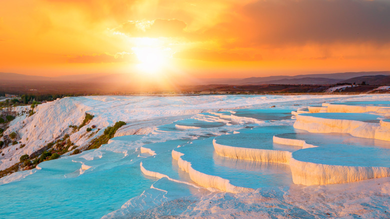 White natural mineral pools and turquoise water at sunset, Pamukkale Water Terraces