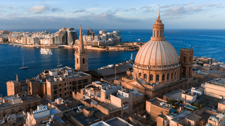 Aerial view of Valletta, Malta with the basilica dome, Marsamxett Harbour and Sliema skyline in late afternoon light