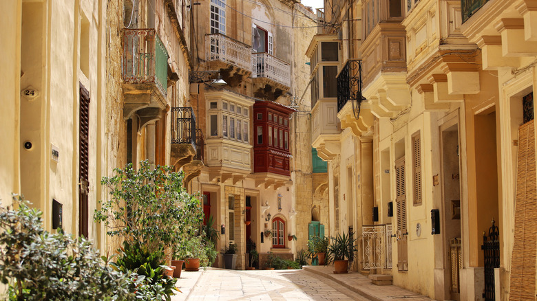 Narrow street in Valletta, Malta, featuring iconic enclosed wooden balconies
