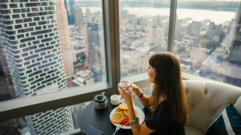 woman alone in hotel with city view