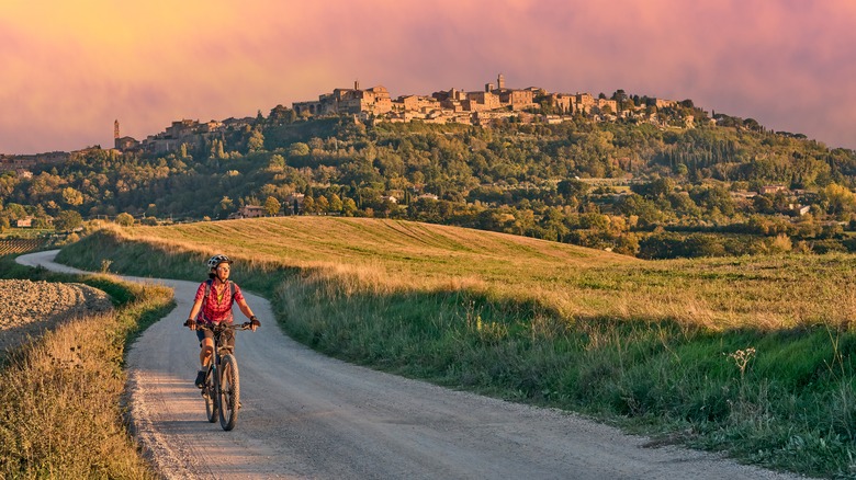 A woman riding an e-bike on a scenic route in Italy