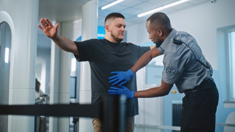 Man being screened at airport security