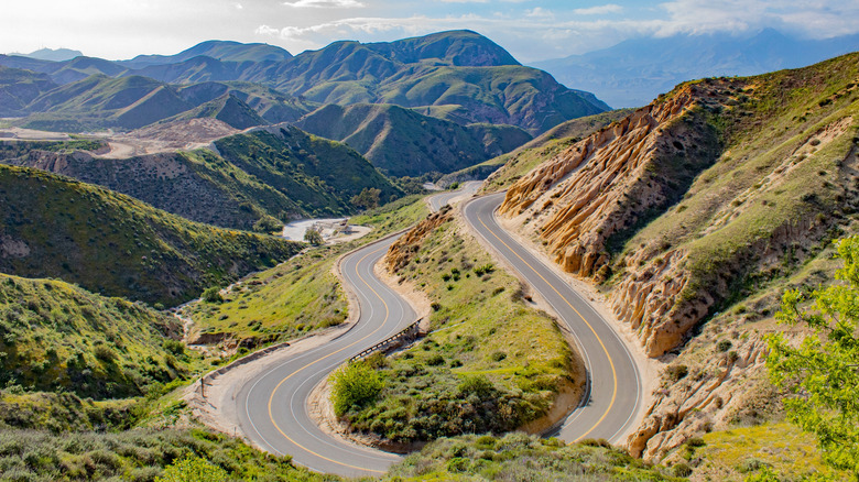 Mountain road with green mountains and blue sky