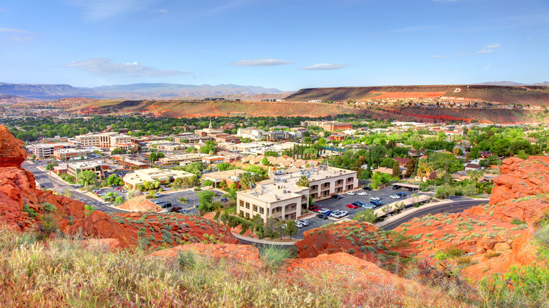 Town surrounded by green trees and red-rocks