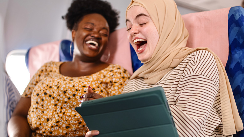 friends laughing on a plane