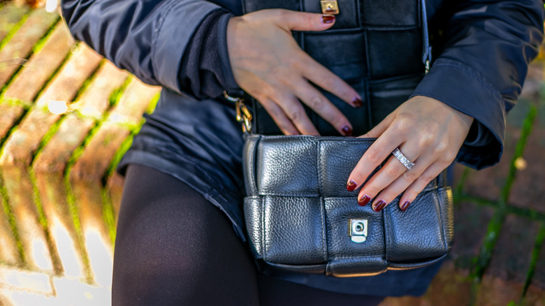 A woman checks her leather purse