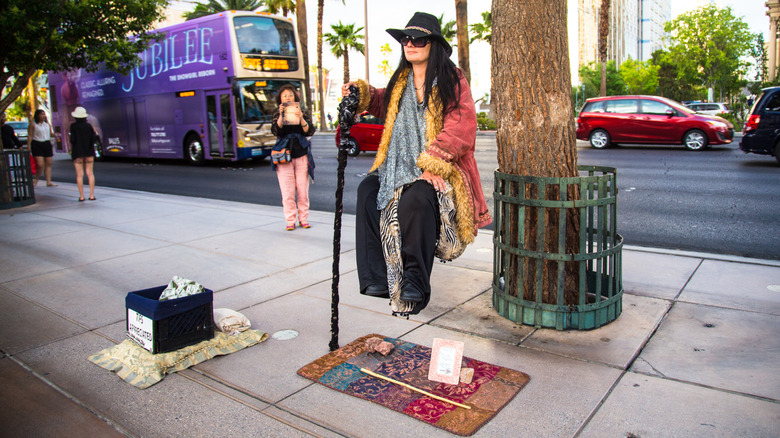 woman doing a levitation trick on a sidewalk