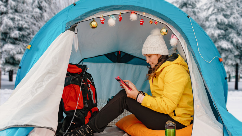 A woman reading in a tent in the snow