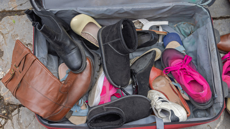 suitcase overflowing with shoes