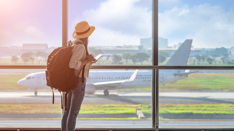 woman in airport watching plane