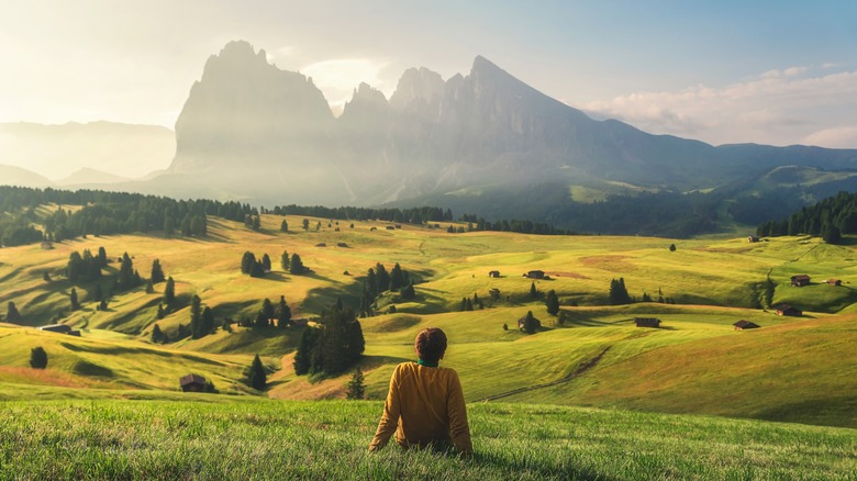 Hiker relaxing on a meadow in the Dolomites