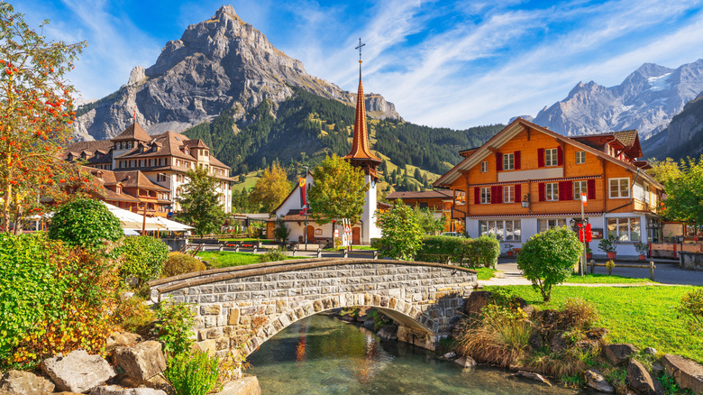 The center of Kandersteg with a stone bridge over the Kander River and traditional architecture with the Bernese Alps in the background.