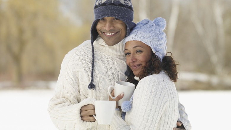 Couple with mugs outside in winter