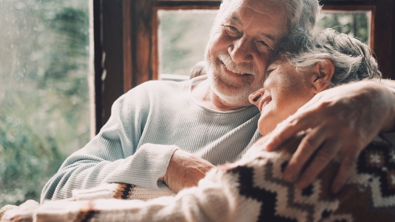Elderly couple holding each other