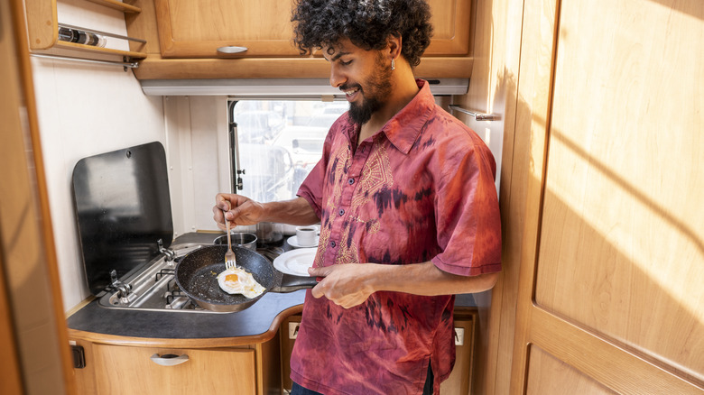 Traveler cooking eggs in an RV
