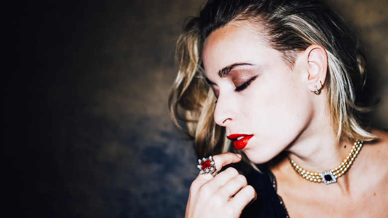 Portrait of a woman wearing a ruby ring and sapphire necklace