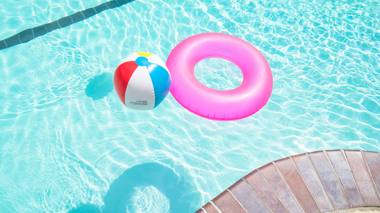 Beach ball and lifesaver for kids in blue swimming pool