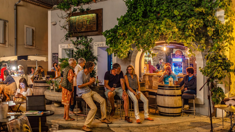 People drinking outdoors at a European bar.