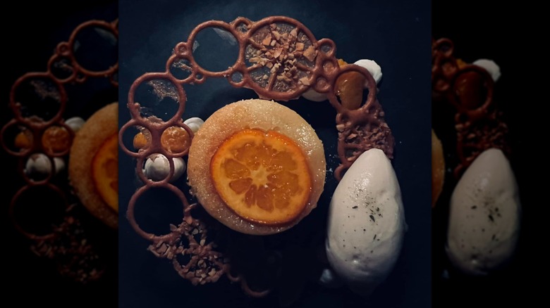 Restaurant tables and smartly-dressed waiter, interior of Bacchanalia, Atlanta