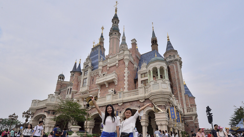 Shanghai Disneyland castle guests giving hats-off