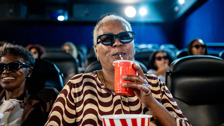 Woman drinks soda movie theater